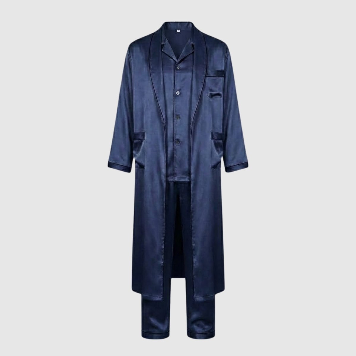 Product-only flatlay image of the Kouvr navy satin robe, button-down shirt, and pants arranged on a light grey background.

