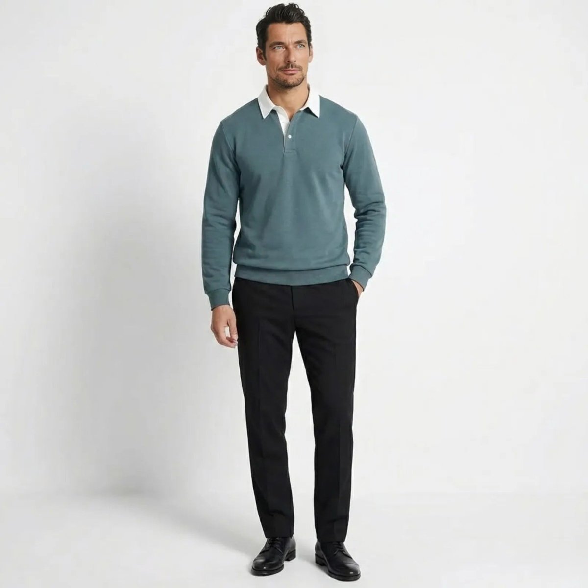 Man wearing Kouvr's grey blue long-sleeve knit polo sweatshirt with a white contrast collar, paired with black trousers.