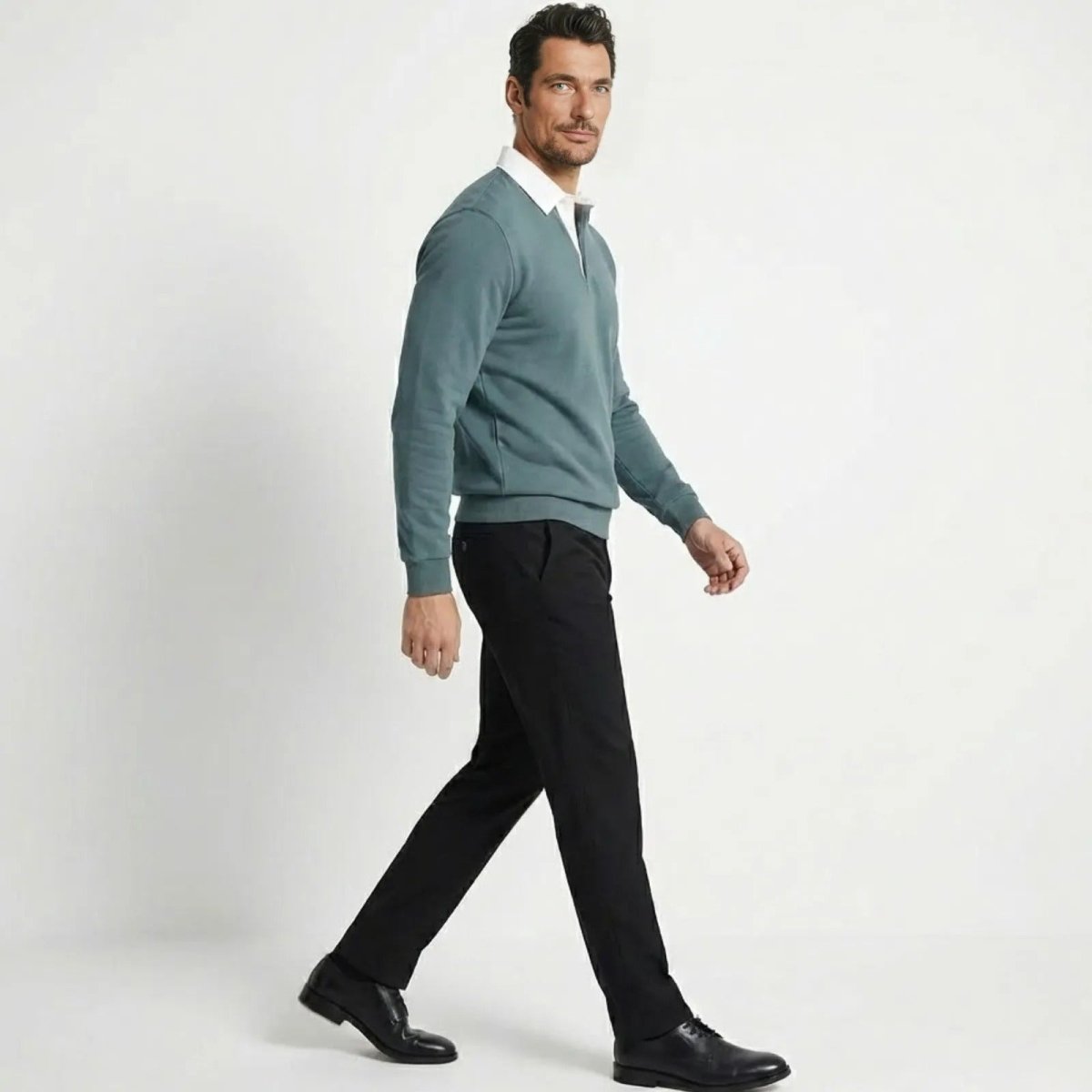 Side view of a man walking in a grey blue contrast collar polo sweatshirt, showing the tailored fit and silhouette.