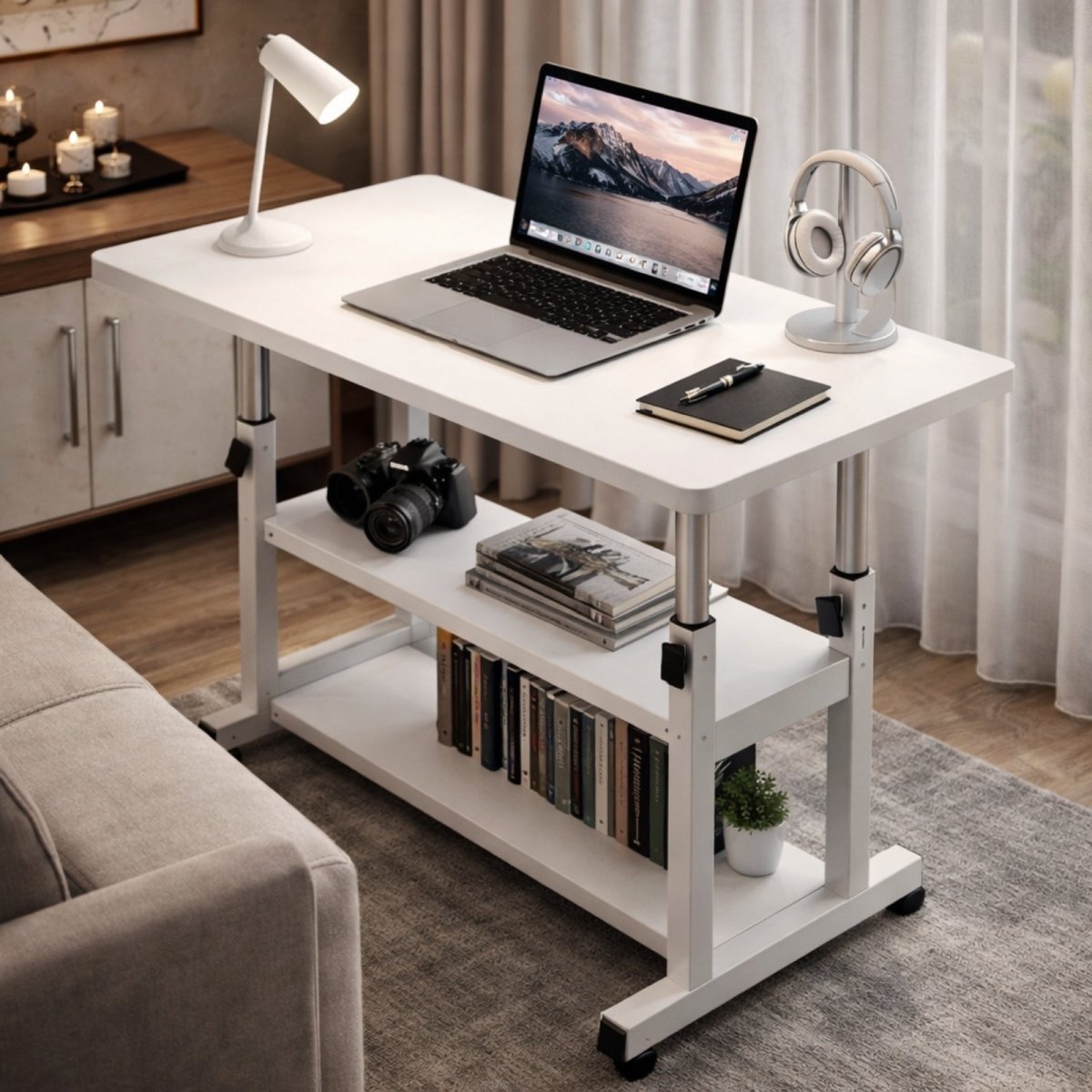 Side view of a white mobile workstation next to a sofa, used as a laptop desk with books and a camera displayed on its two lower shelves.