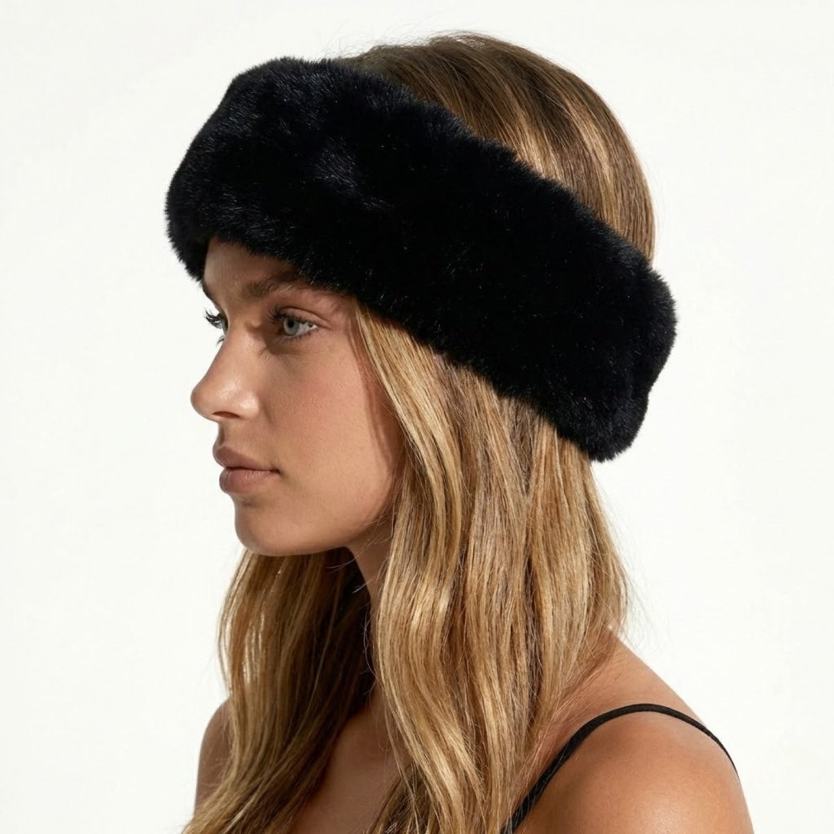 Side profile of a model wearing the Kouvr Nancie plush black faux fur winter headband.