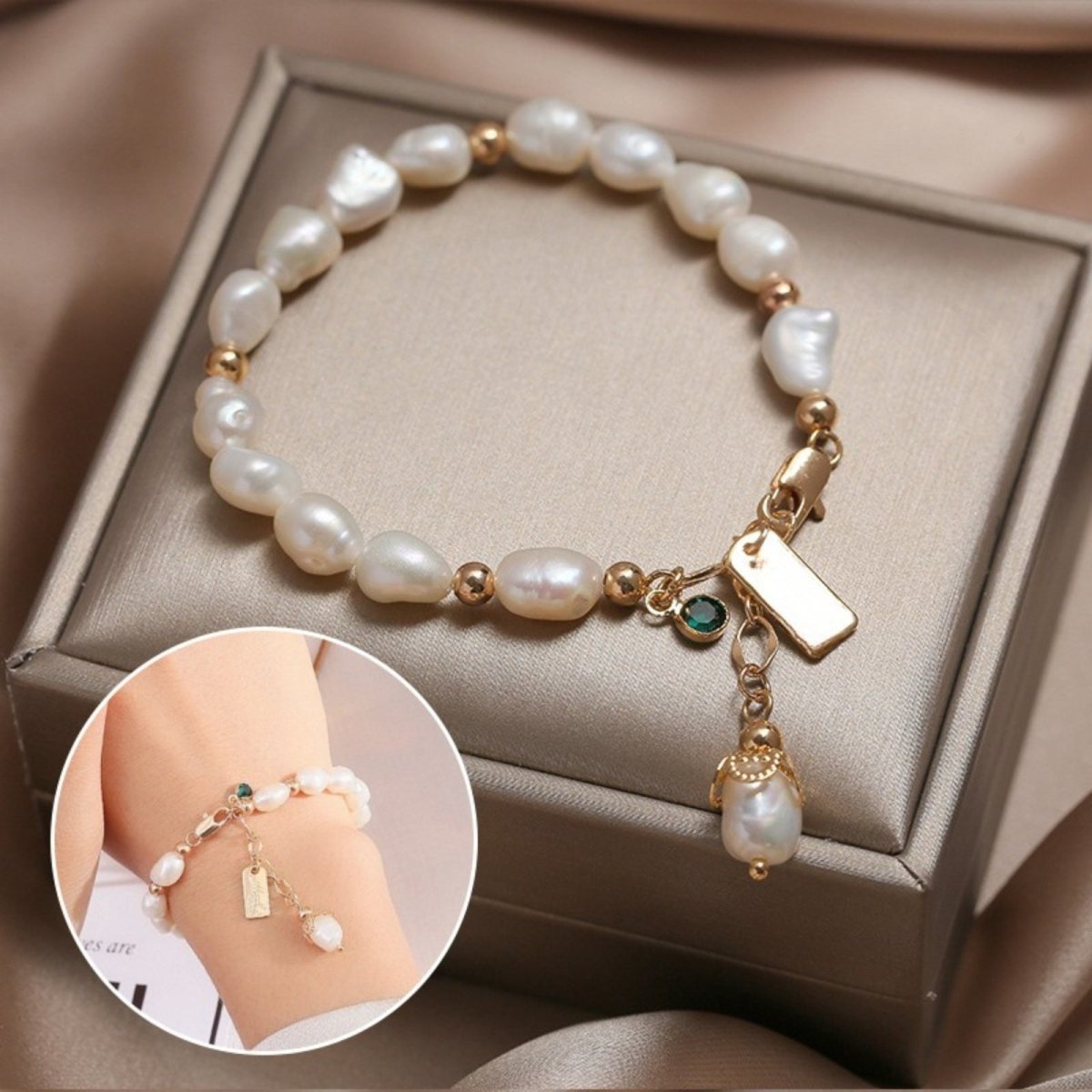 The Nathalia Baroque Pearl Bracelet by Kouvr Fashion with 18k gold beads, an emerald charm, and a pearl drop charm on a white background.