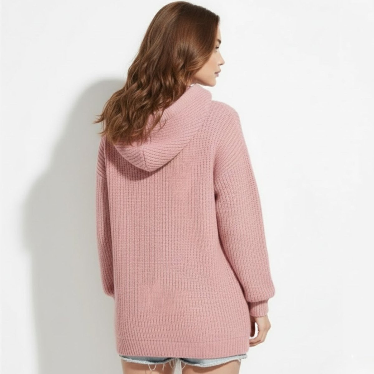 Back view of the Kouvr oversized knit hoodie in pink, showing the generous hood and chunky vertical rib texture.