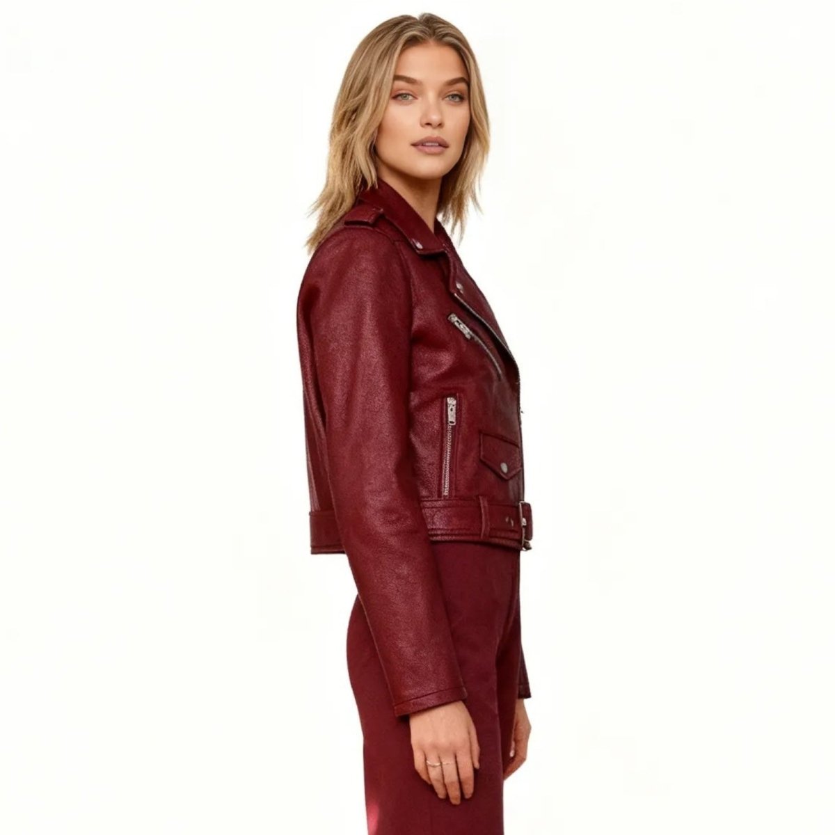 Side profile of a model wearing the Kouvr Reshane burgundy faux leather biker jacket, highlighting the sleeve details and tailored fit. 