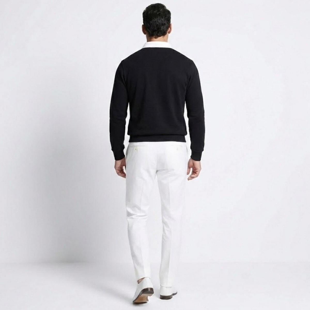 Back view of the Kouvr Rhodes black knit polo sweater, showcasing the clean lines and white contrast collar.
