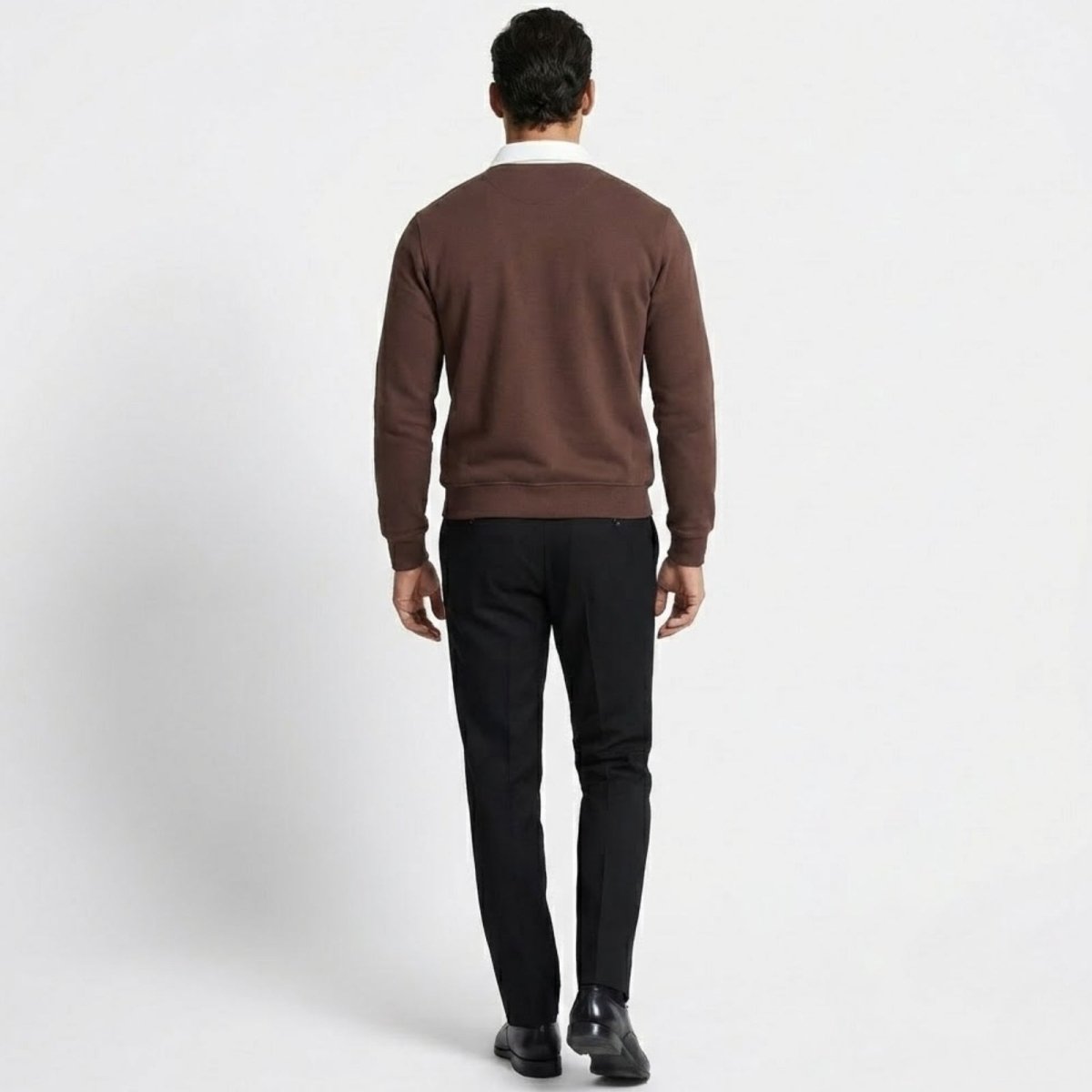 Back view of a man wearing the Kouvr Rhodes dark brown long sleeve polo sweater, displaying the fit across the shoulders and back.