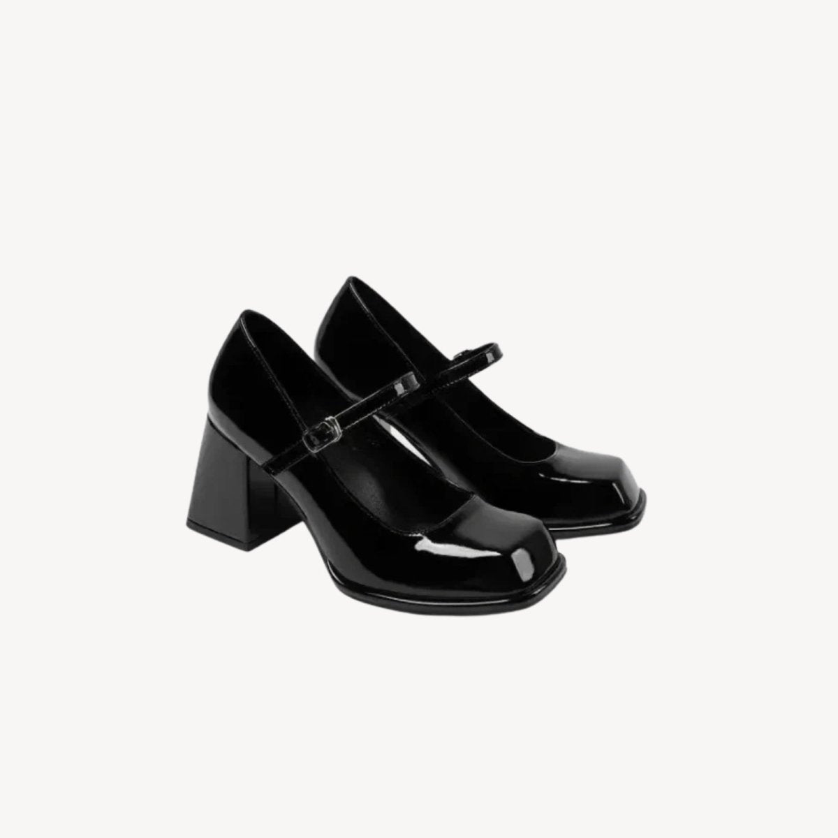 A pair of Kouvr Sabrina black patent pumps shown from a three-quarter angle, highlighting their glossy finish and statement silhouette.

