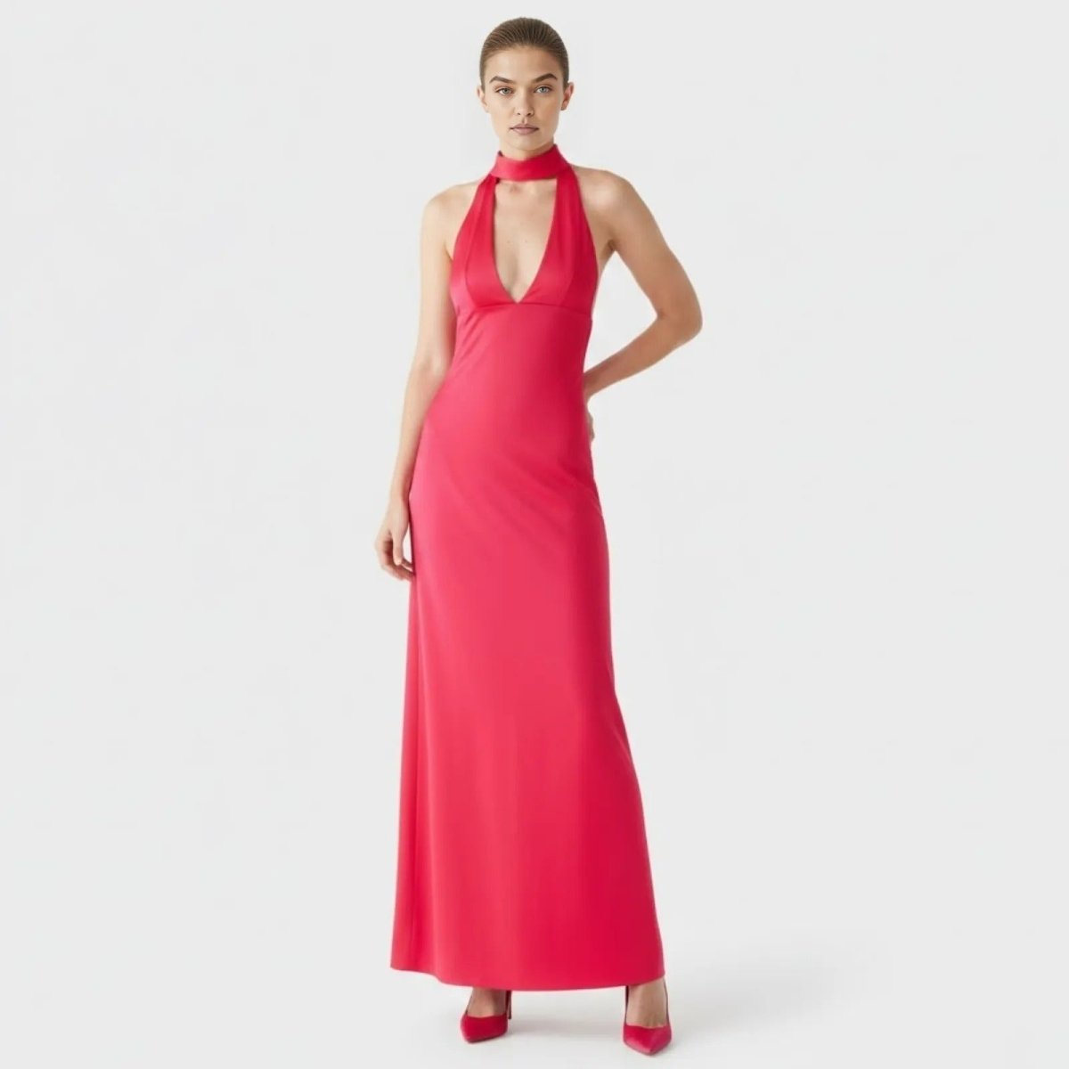 Model wearing the Kouvr Sharon fuchsia red halter neck maxi dress with a plunging v-neck, viewed from the front against a white background.