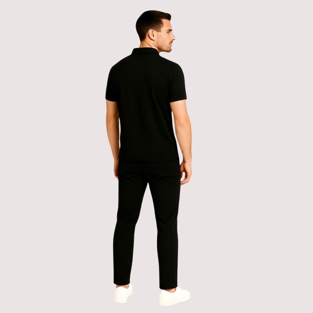 Man wearing a black kouvr outfit on a light gray background