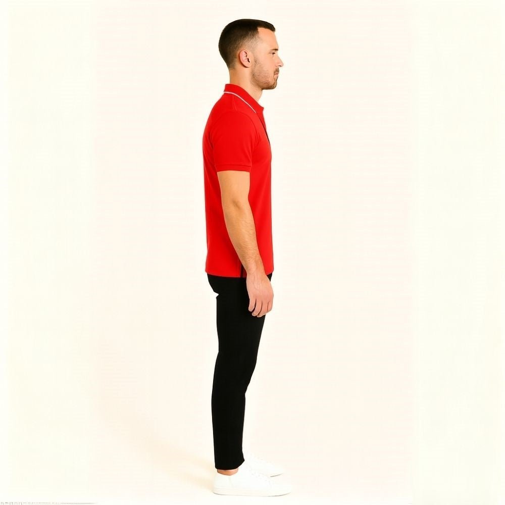 Man wearing a red kouvr polo shirt and black pants on a white background