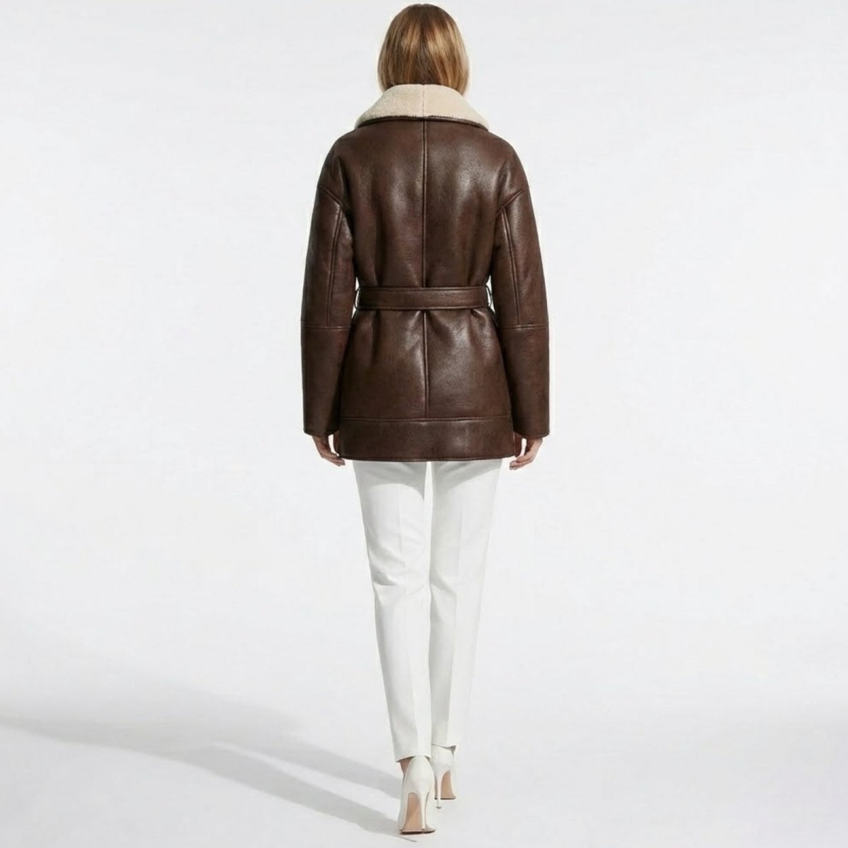Back view of the Kouvr Suzanne brown belted shearling jacket on a model, highlighting the fit and seam details.
