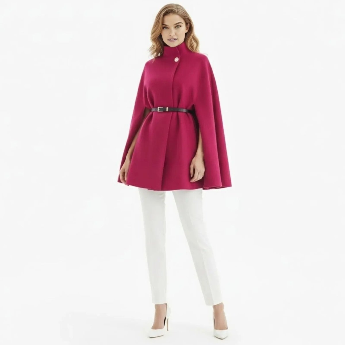 Model wearing the Kouvr Traci belted cape coat in pink, styled with a high funnel neck and white tailored trousers.