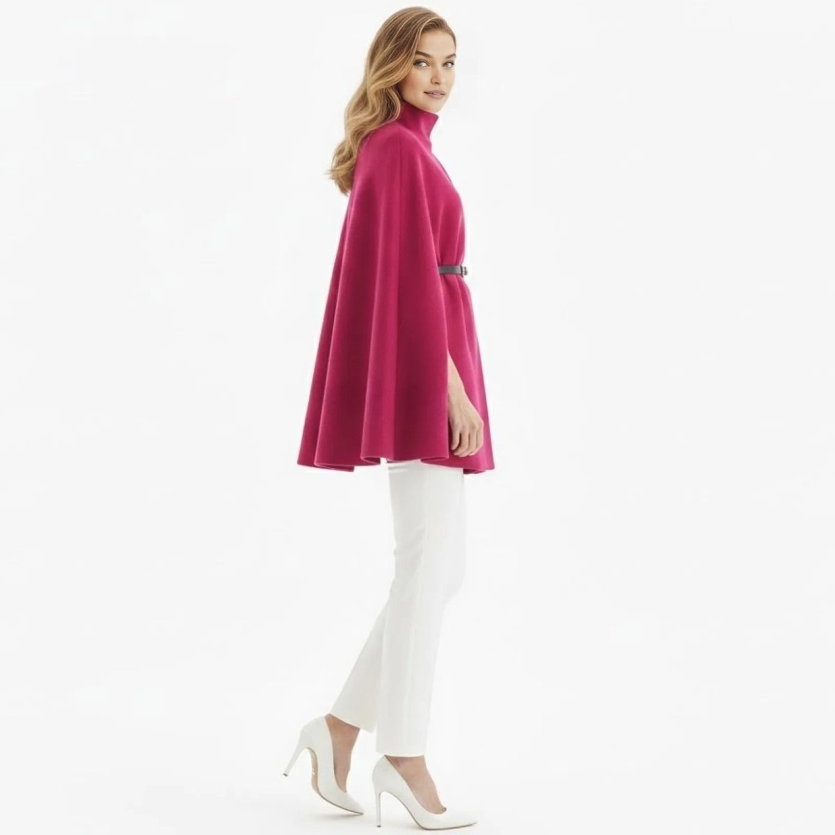 Side profile of a woman wearing the Kouvr fuchsia pink cape coat, showcasing its A-line silhouette and arm slit.