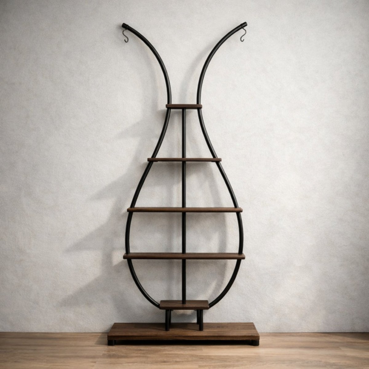 The Kouvr sculptural vase shaped plant stand in matte black metal and dark wood, shown empty against a white studio background to highlight its form.
