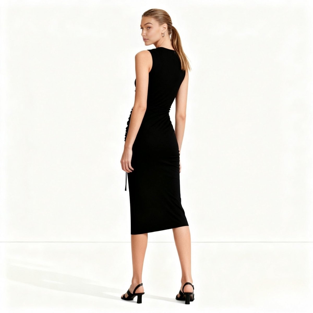 Woman wearing a black Kouvr sleeveless dress on a white background