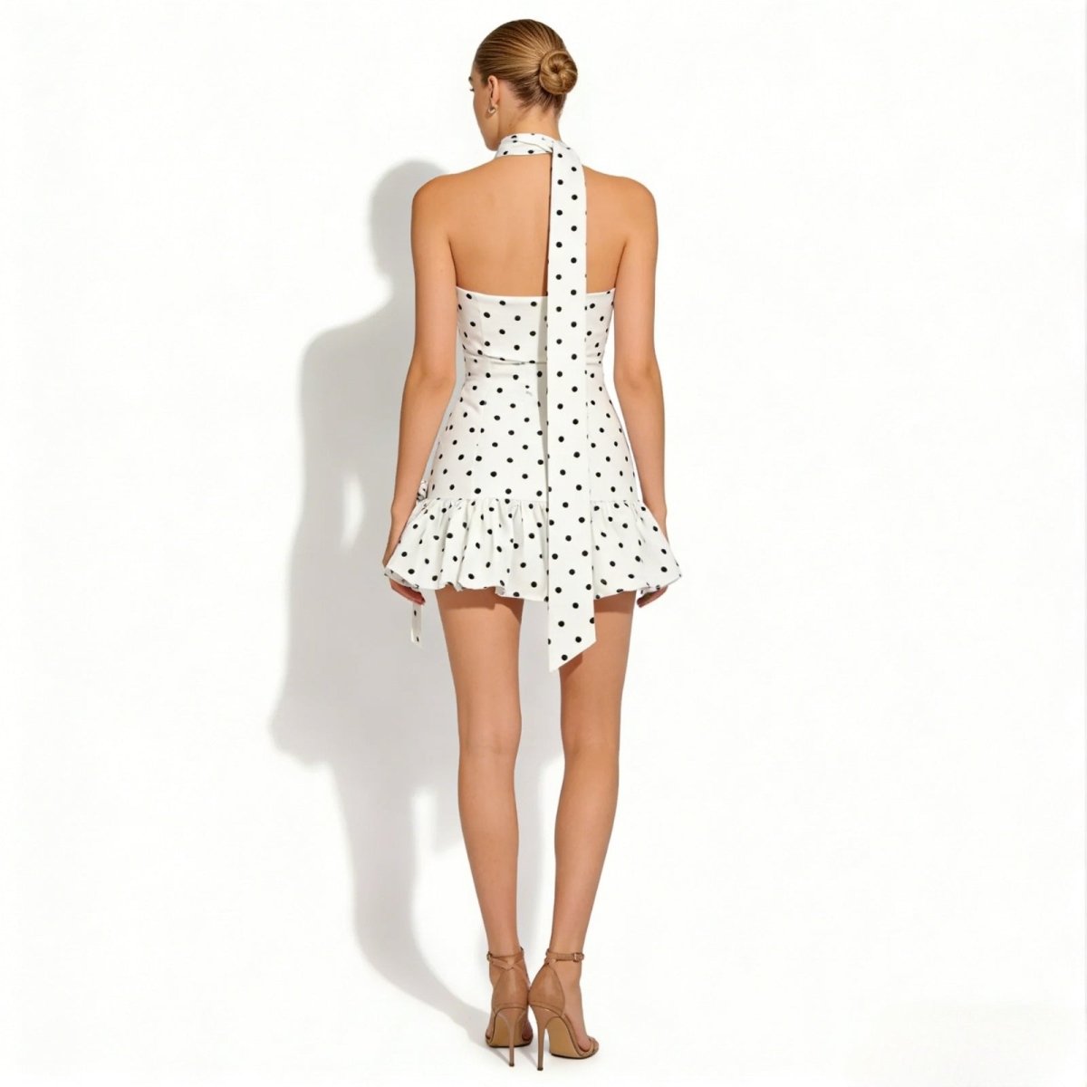 Back view of the Zia halter neck polka dot dress from Kouvr Fashion, showcasing the open back and long neck tie detail.