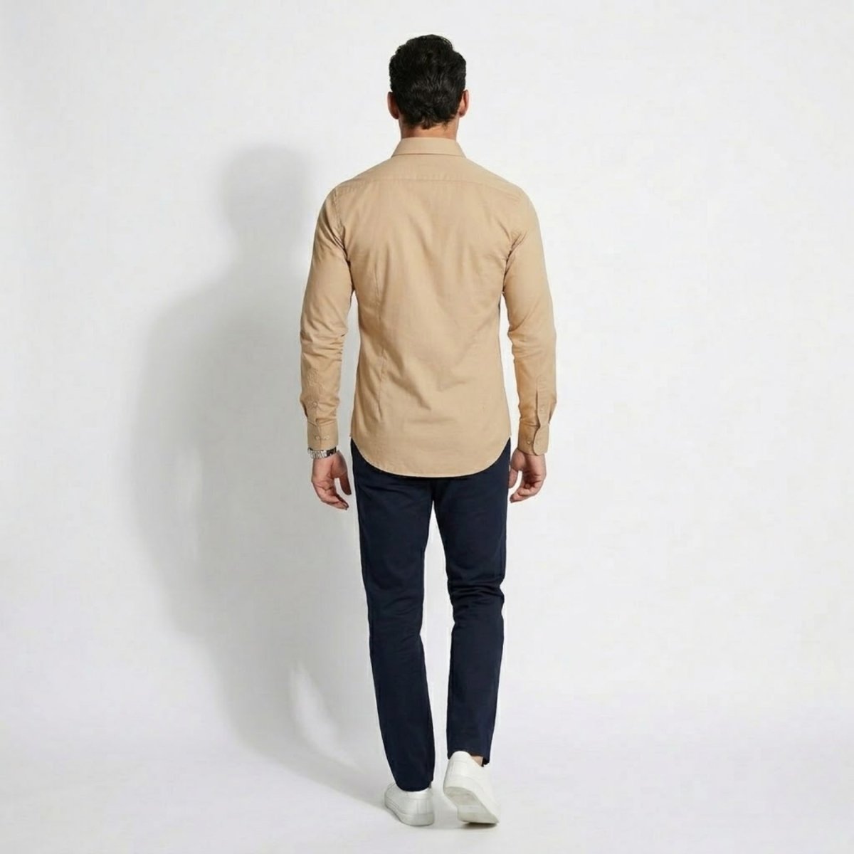 Back view of men's affordable luxury sand color long sleeve shirt showing tailored fit and curved hem detail.