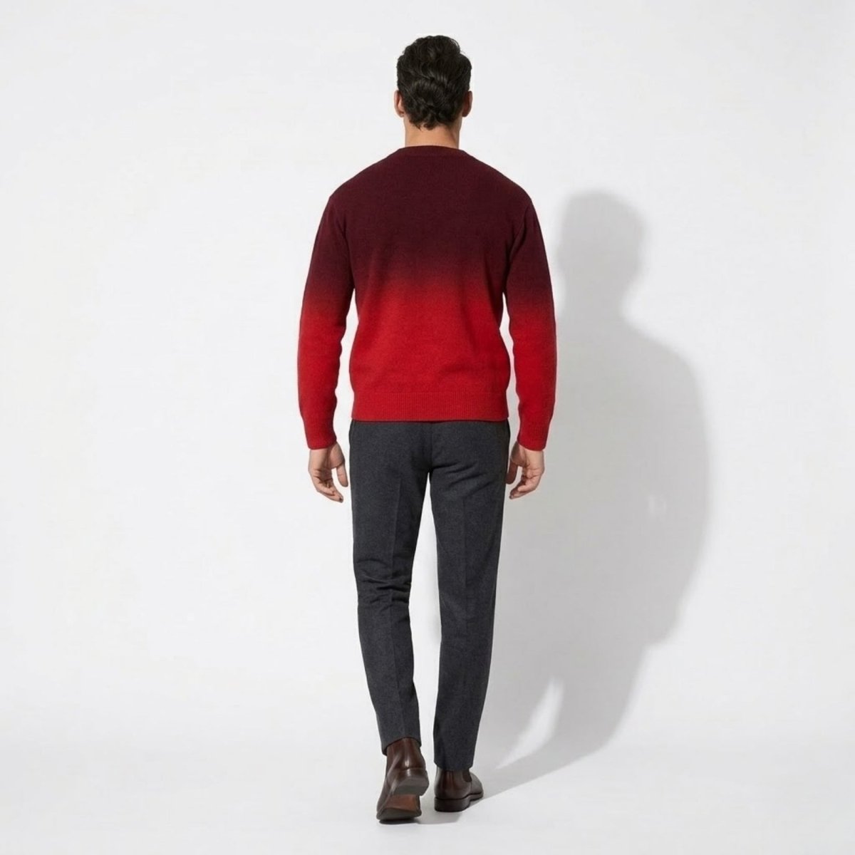 Back full body view of Kouvr men's designer dark red to bright red ombre knit cardigan paired with tailored dress pants.