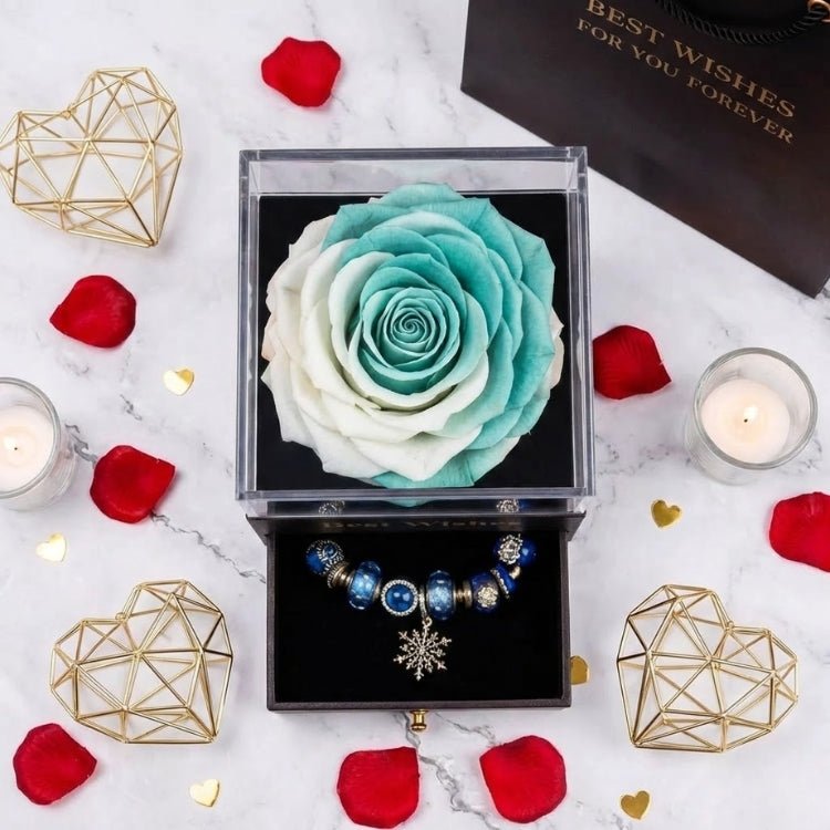 Overhead shot of a mint green and white gradient eternal rose in a luxury jewelry box with "Best Wishes" gold branding.