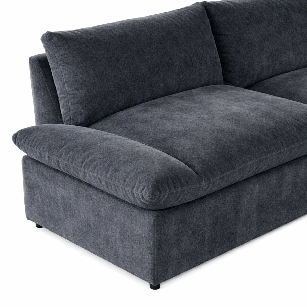 Modern dark grey cloud sectional styled in a living room with a round wood coffee table and rug