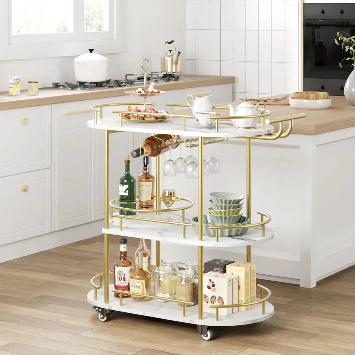 Gold serving trolley styled as a tea and coffee station in a white modern kitchen, showcasing the top shelf guard rail and spacious tiers. 