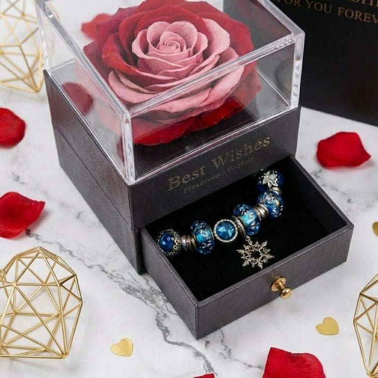 Close-up angled view of a unique red and pink gradient preserved rose inside a black gift box with an open jewelry compartment.