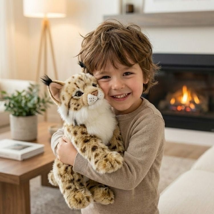 Smiling toddler boy with brown hair lovingly hugging a soft, cute, lifelike Kouvr lynx plush toy.