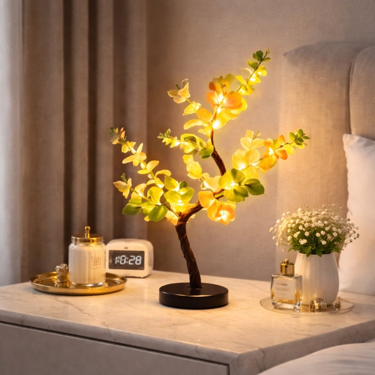 Detailed view of the unlit artificial botanical tree showing realistic green leaves, soft flowers, and a textured bark stem on a black base.